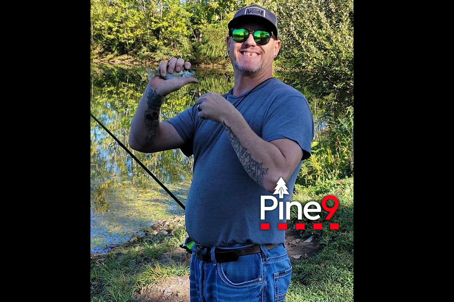 pine 9 JettyHawk fishing rod holster hands free hip rod hip holder holding a sunfish next to a pond with his rod in holster