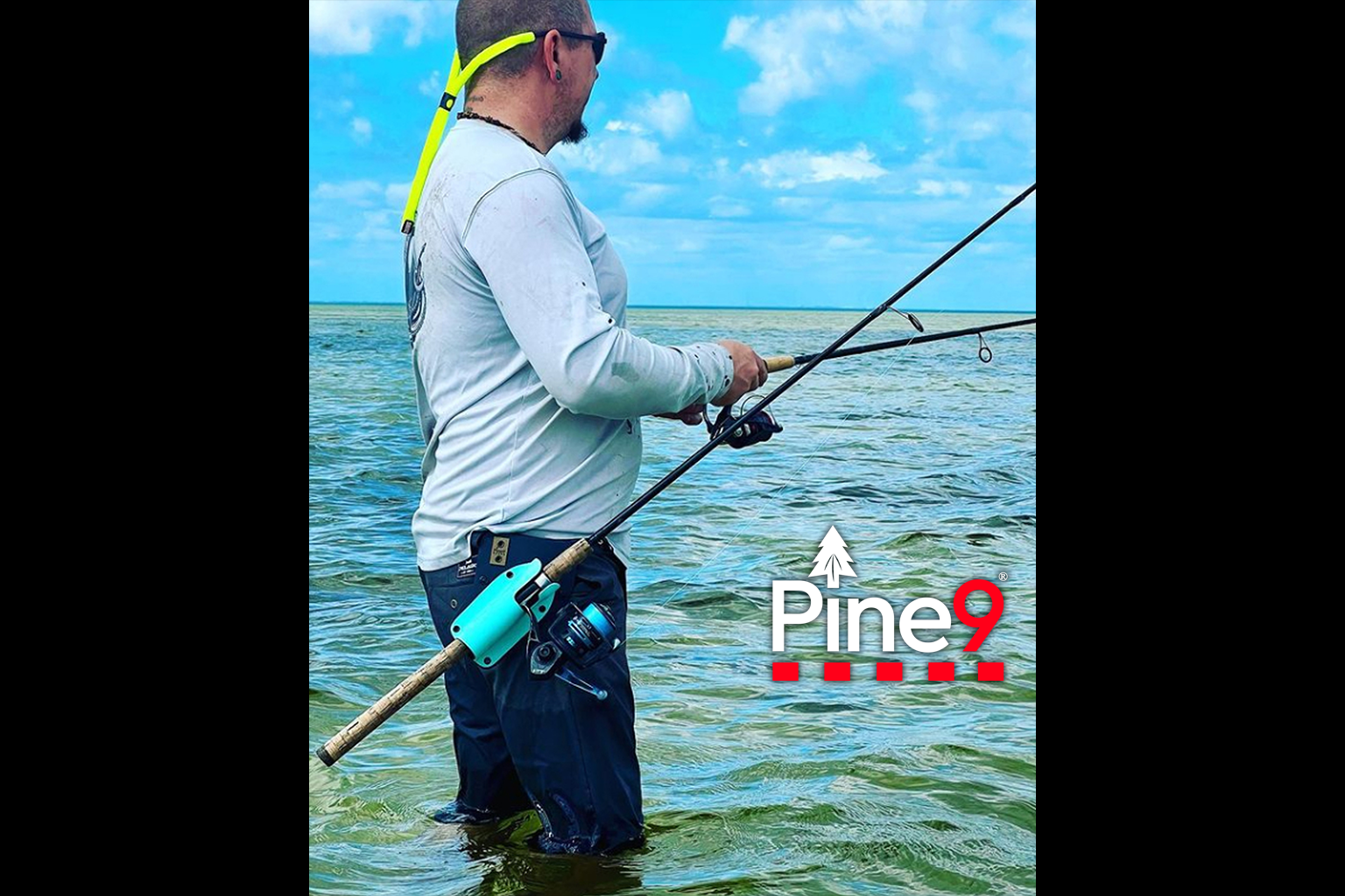 pine 9 JettyHawk fishing rod holster hands free hip rod hip holder man wading in ocean water, fishing with two rod and one in the holster