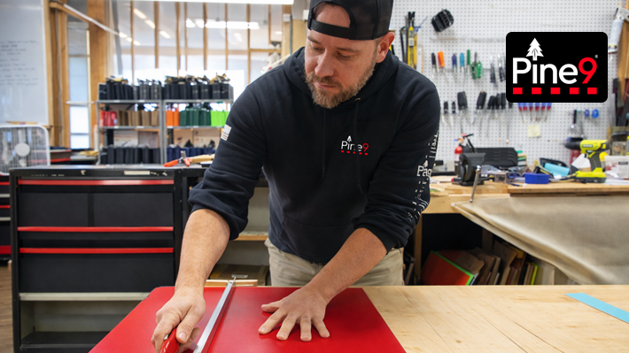 Pine 9 Holsters founder cutting material in workshop while manufacturing fishing rod holsters in New Hampshire showing hands-on small batch production process workbench tools organized shop environment and American made fishing rod holster craftsmanship