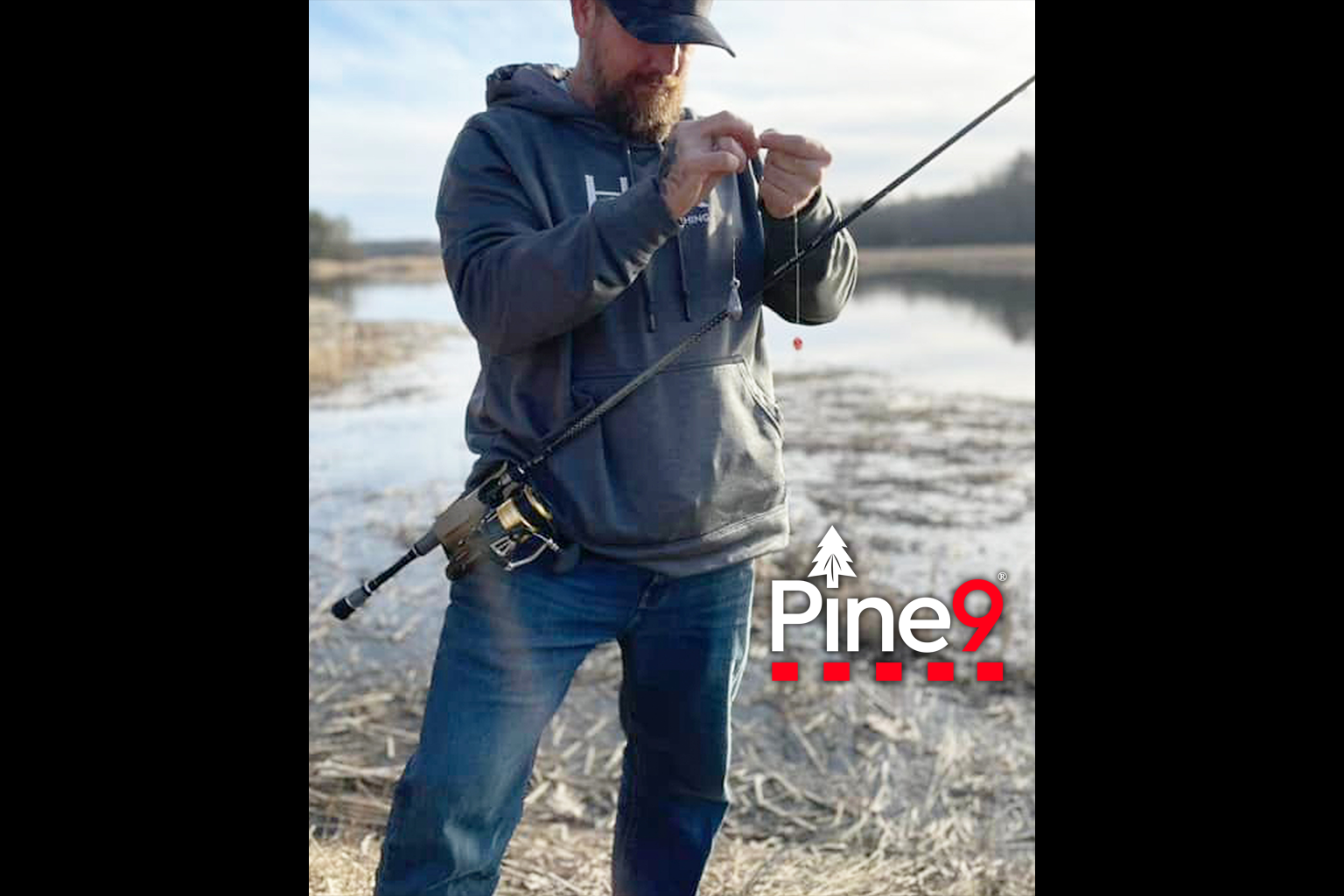 pine 9 JettyHawk fishing rod holster hands free hip rod hip holder man adjusting his hook with his rod holstered next to a large pond