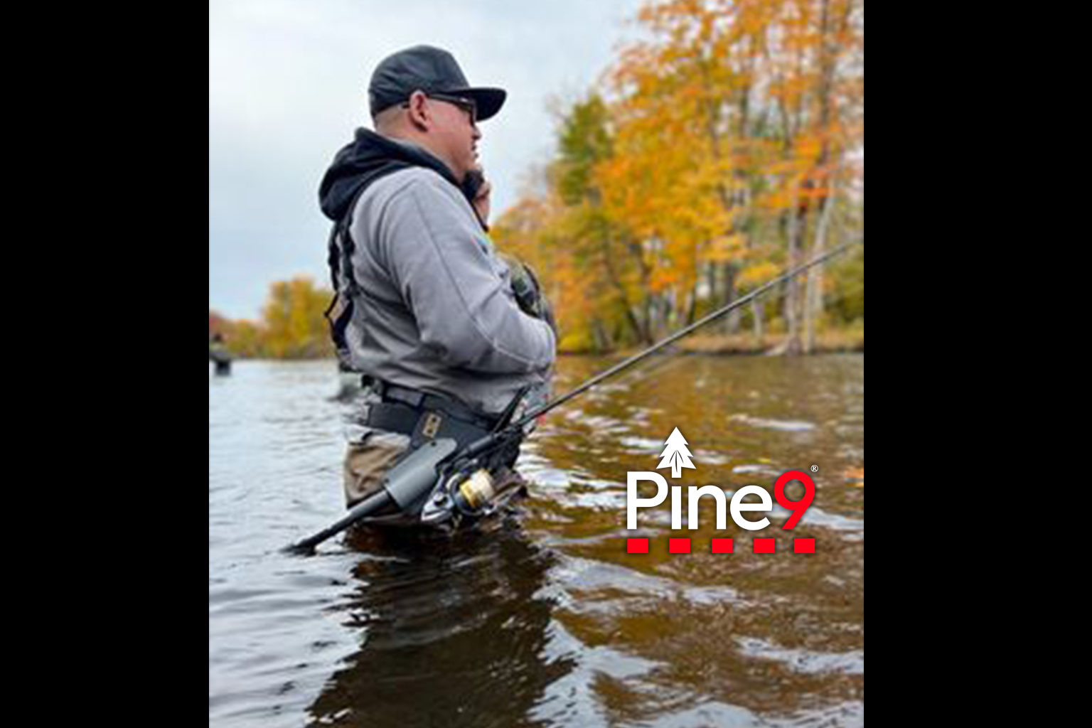pine 9 JettyHawk fishing rod holster hands free hip rod hip holder man standing in river talking on phone with his rod safely holstered while he is wading